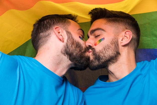 Free Photo | Homosexual couple of men kissing on multicolored flag